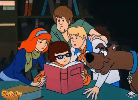 Scooby doo crew reading a book and looking up.