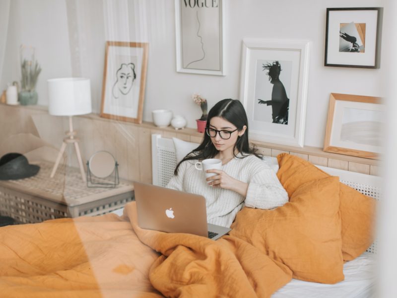 girl in bed at home on her laptop