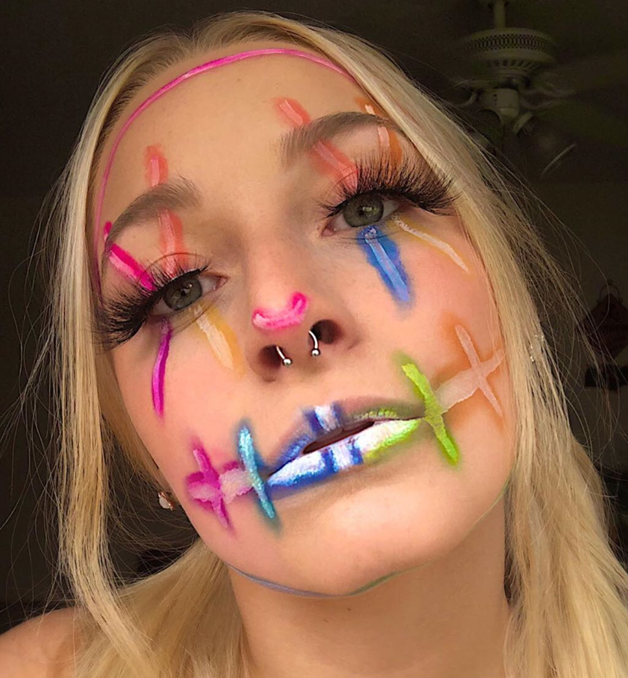 A girl wears neon makeup for her Purge costume.