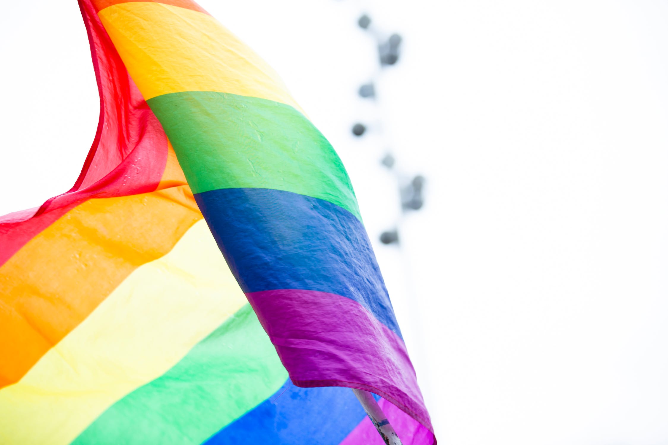 A rainbow flag waves in the air.