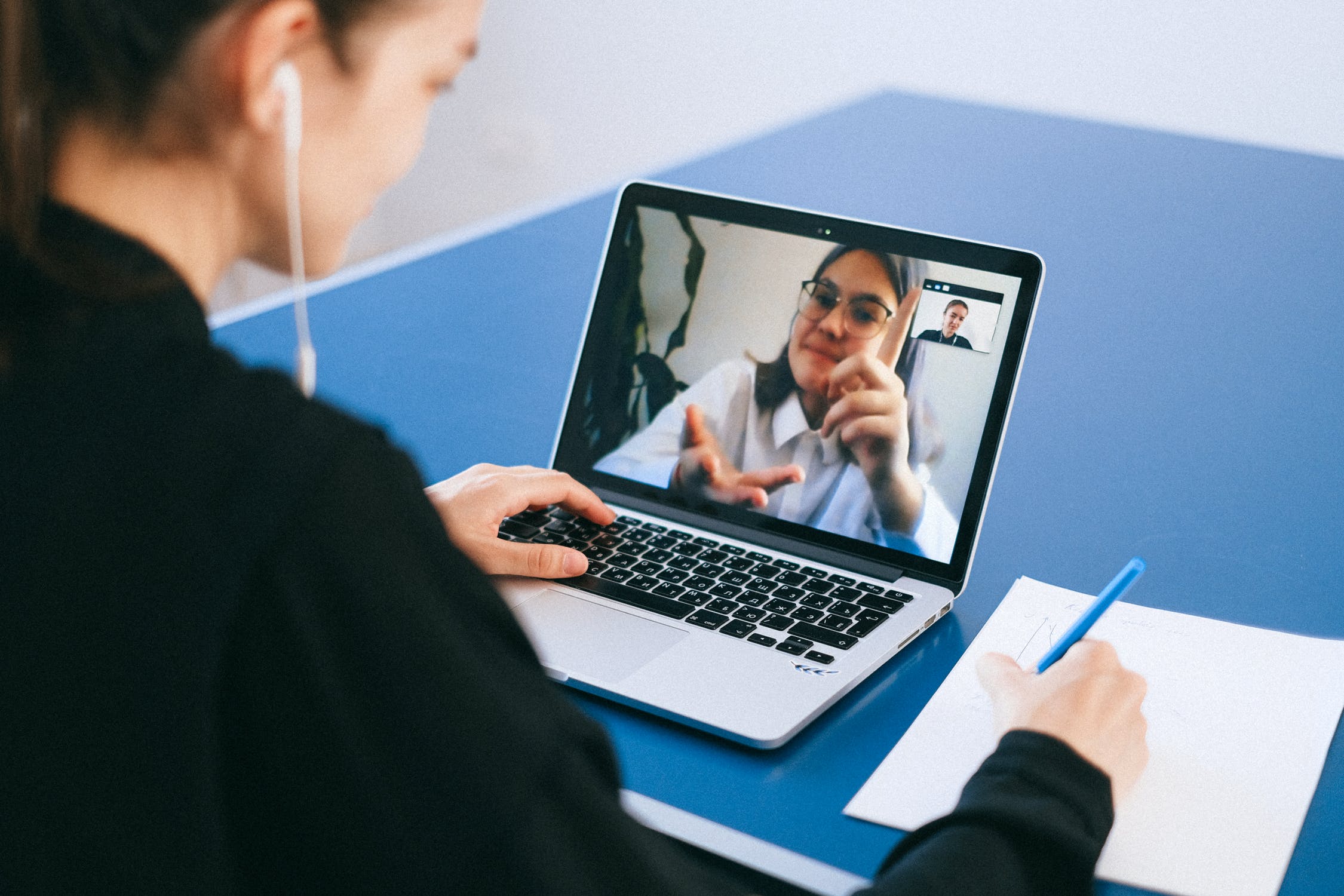 Two individuals talk over a zoom call due to distance learning.