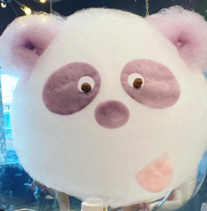 Purple and white cotton candy in the shape of a panda.