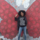 yara shahidi posing in front of a butterfly with an equal rights shirt
