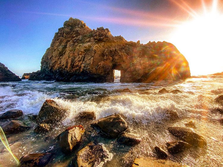 Keyhole Rock in the middle the ocean with the mid-afternoon sun in the background