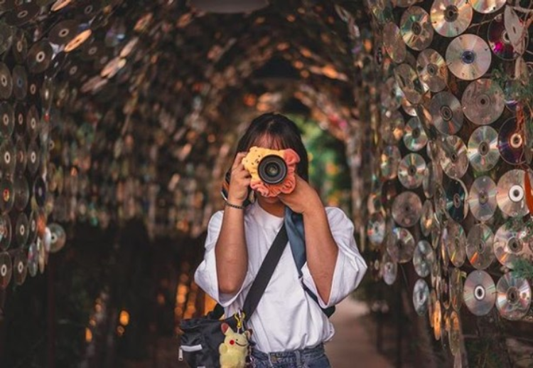 Girl posing in Anti-Mall's tunnel covered with CDs