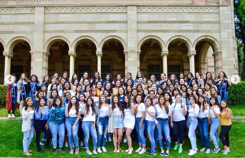 Latinx Women in Hermanas Unidas de UCLA taking a group photo in front of a building.