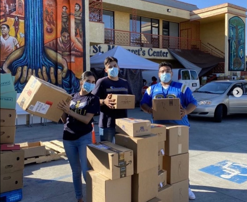 Latinx volunteers in LSHP for LCCM picking up boxes in front of St. Margaret's Center.