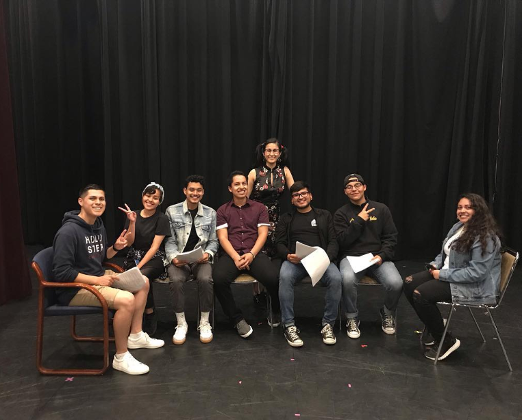 Latinx film students posing on the stage of a theater.