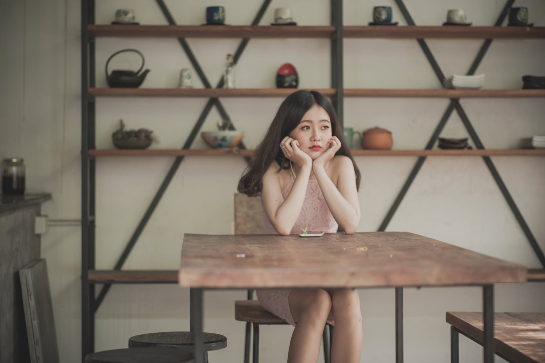 Woman sitting at a table holding her head