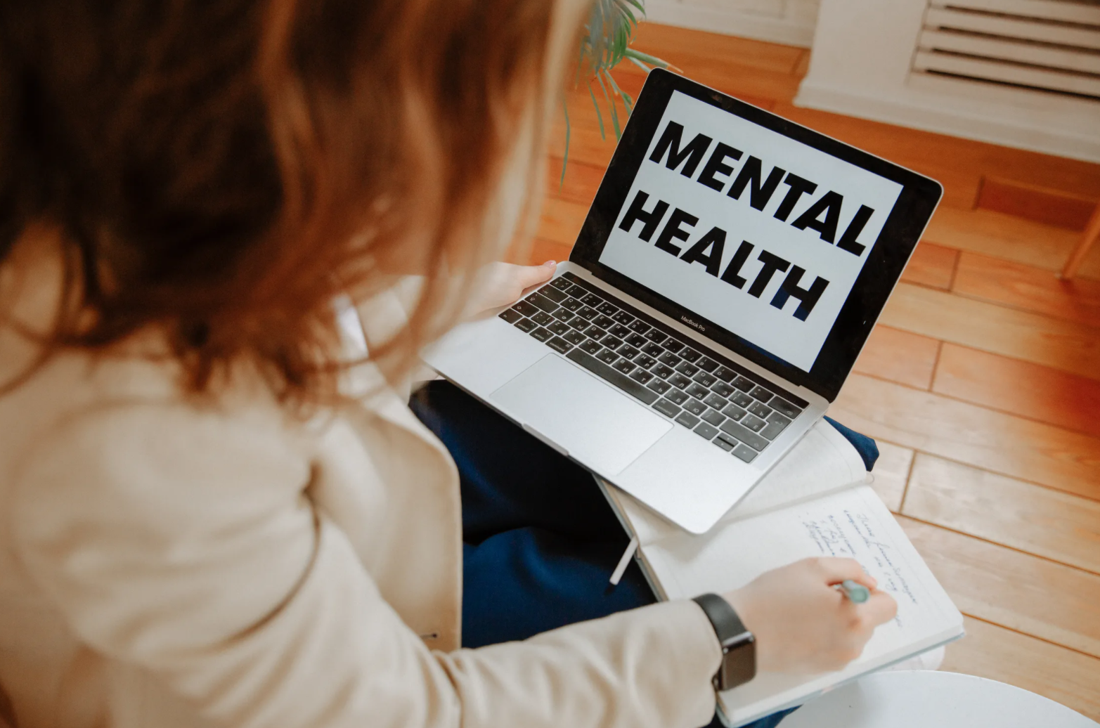 A woman looks at her computer that says "Mental Health" on the screen.