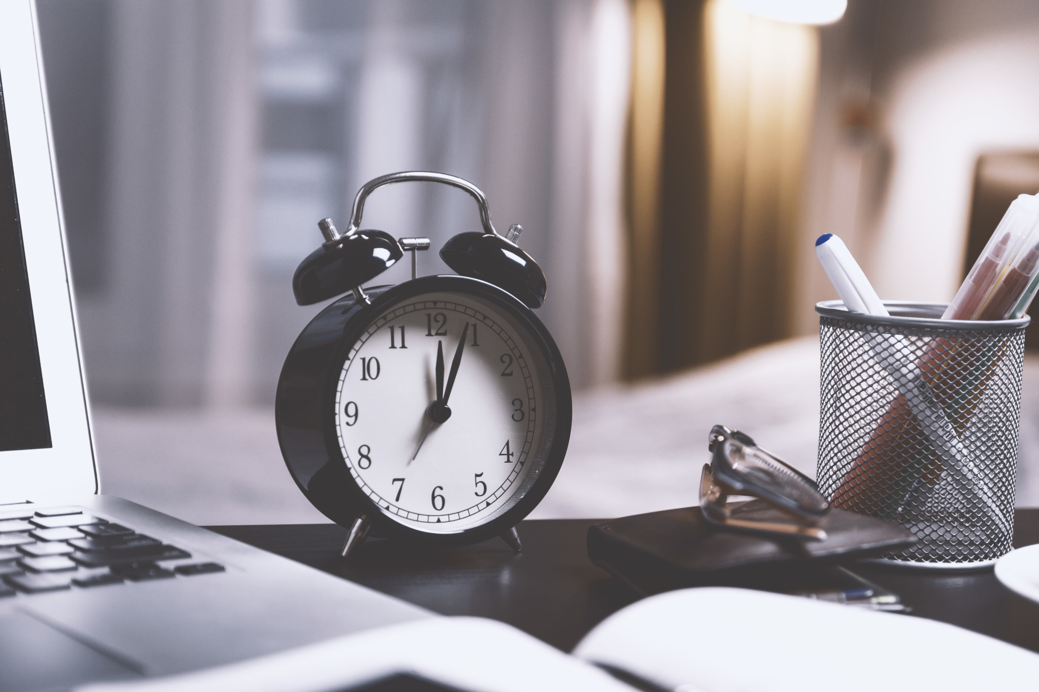 Clock on a desk with a laptop