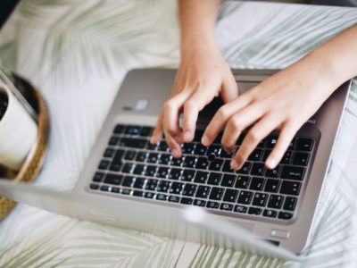 student typing on laptop