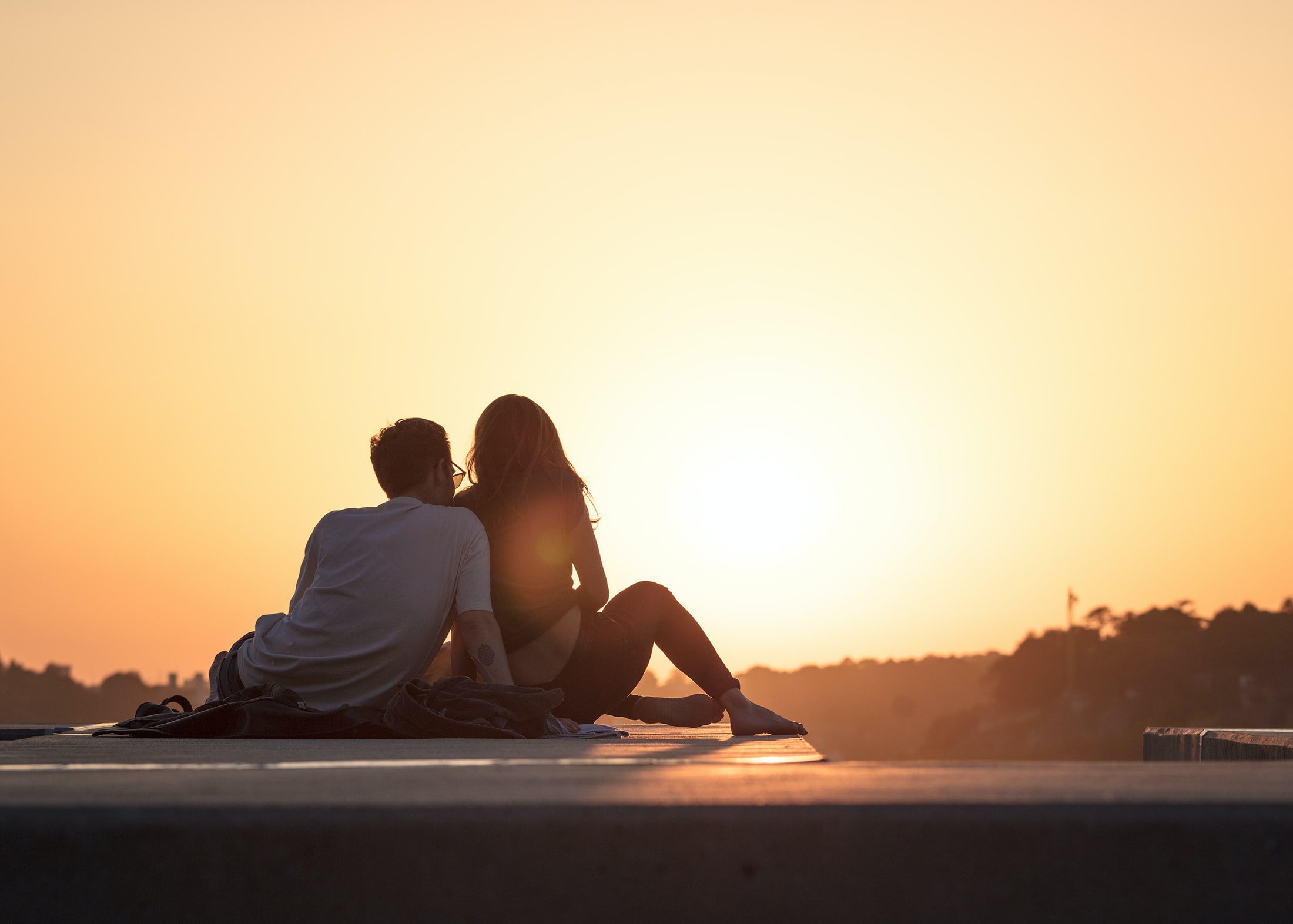 couple sitting by a sunset