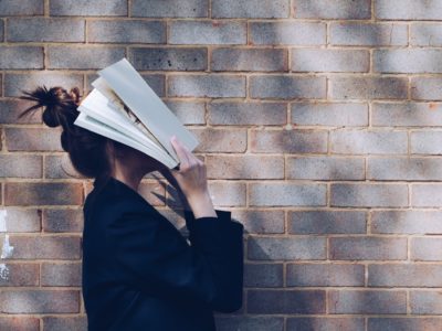 girl with book over her face