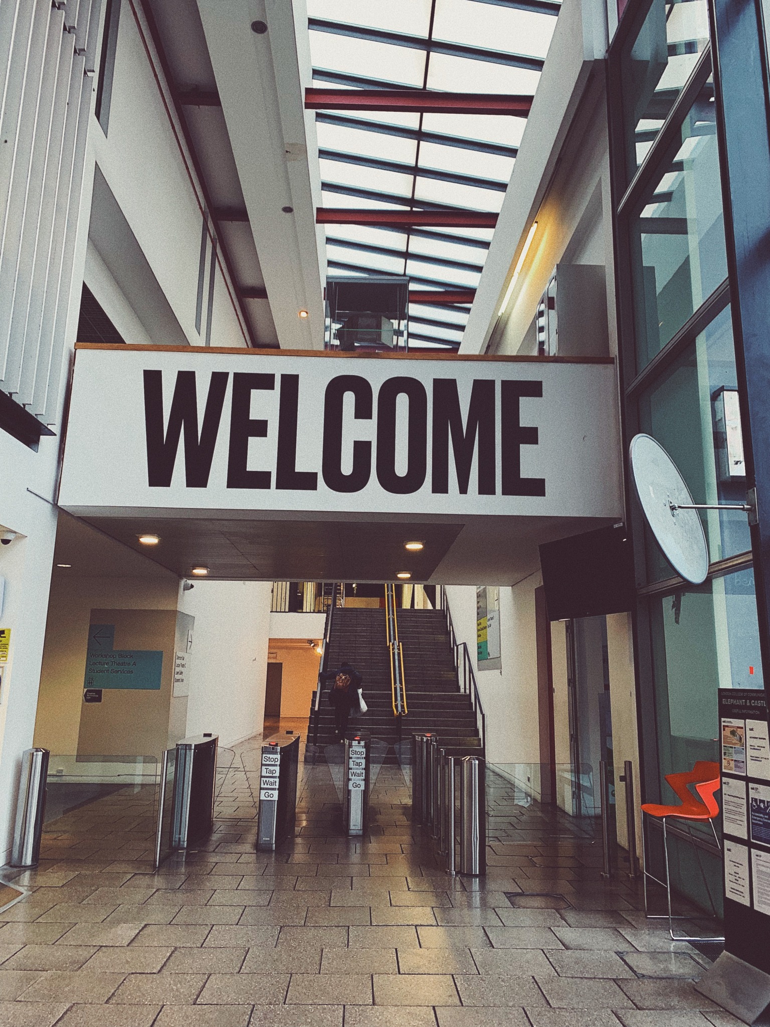 A welcome sign above escalators.