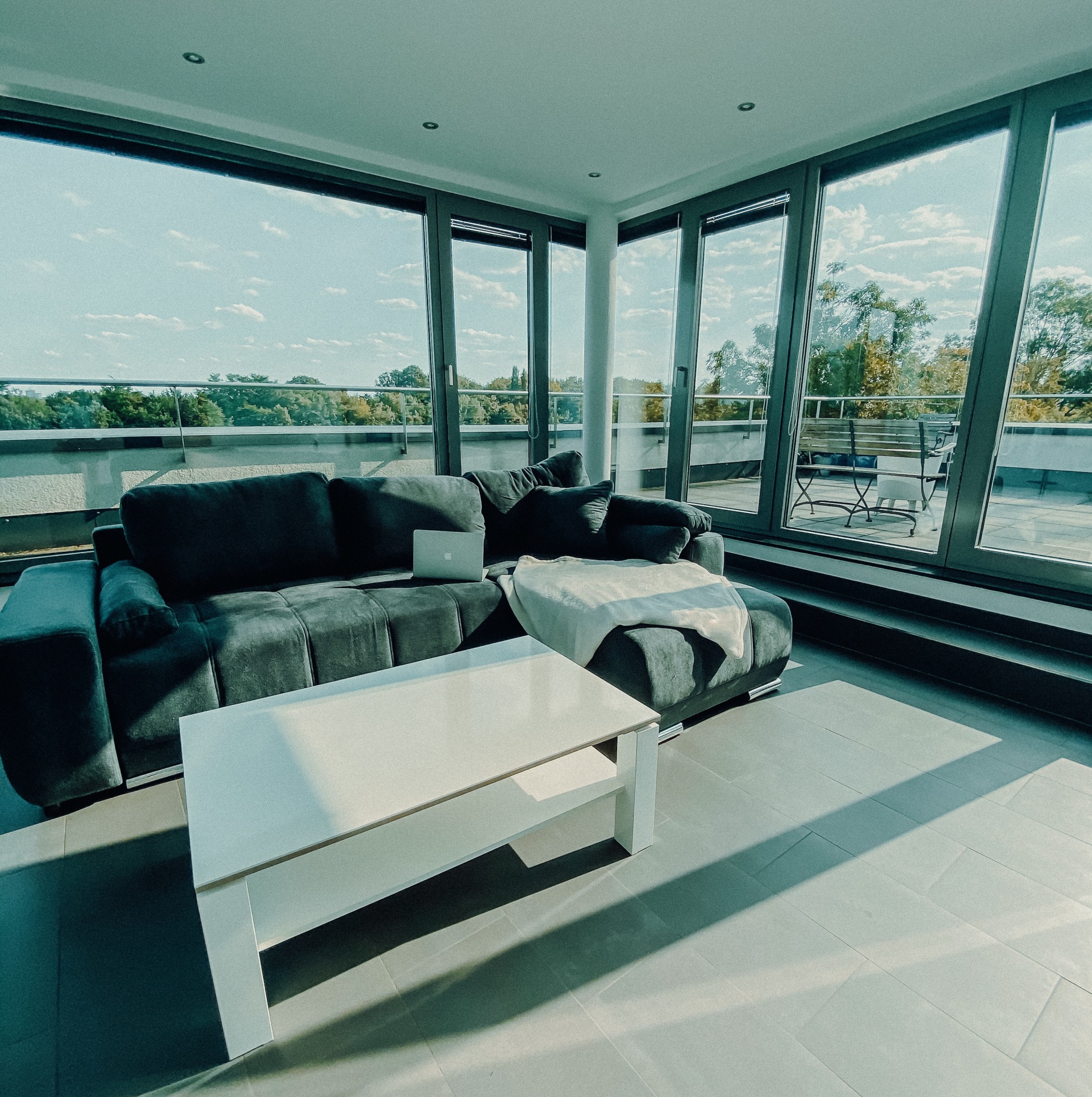 A white and black sofa near a glass window.