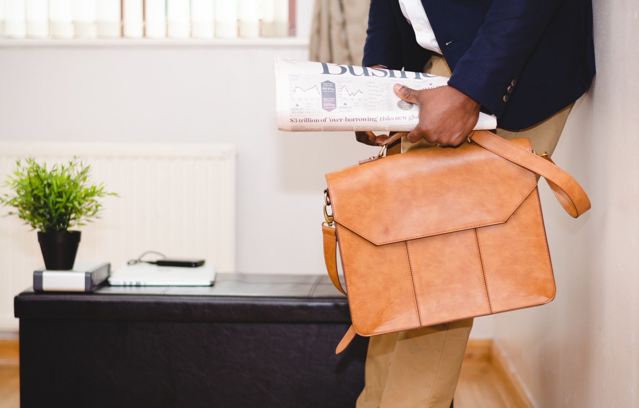 Man holding brown leather bag