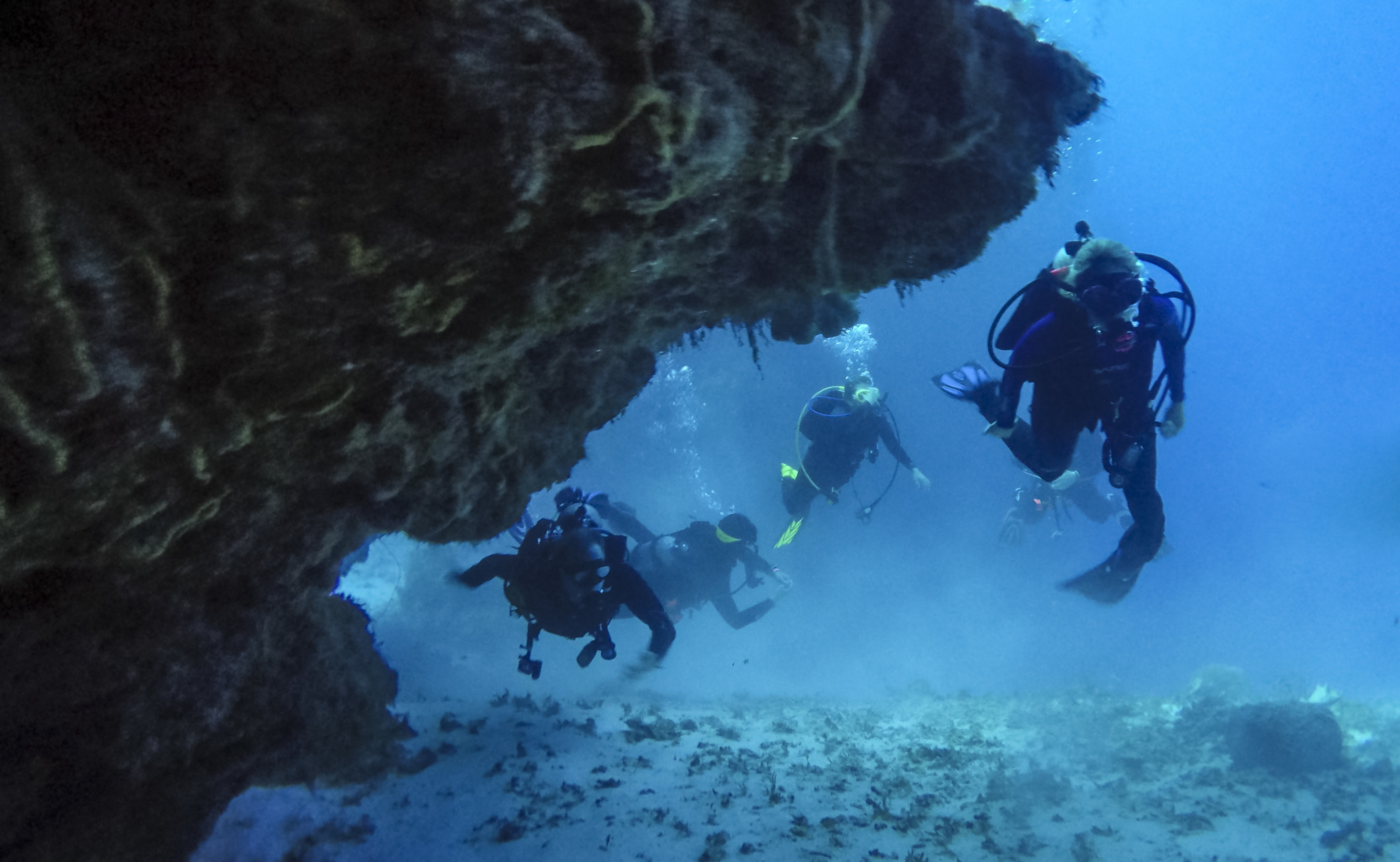 Scuba Divers near a Coral Cave