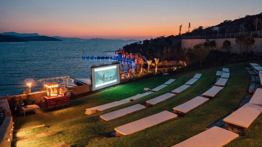 Outdoor amphitheater showing a movie at sunset