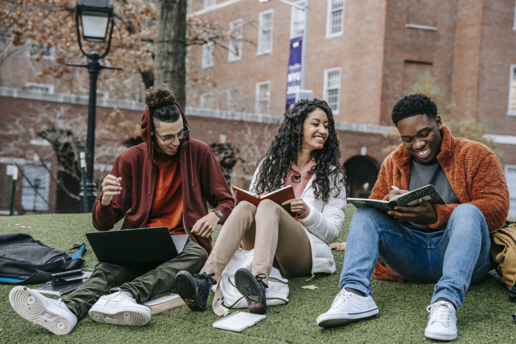 Group of college students sitting outside together. 