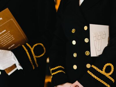 A male and female in the hospitality industry wearing uniforms and smiling