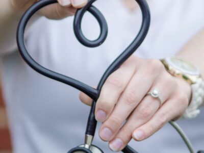 Hands holding out a stethoscope in the shape of a heart