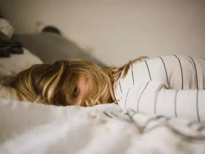 girl lying face down on bed
