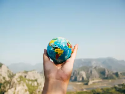 Hand holding a small globe