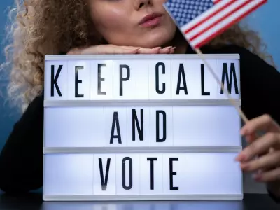 woman holding an American flag and a sign that says keep calm and vote